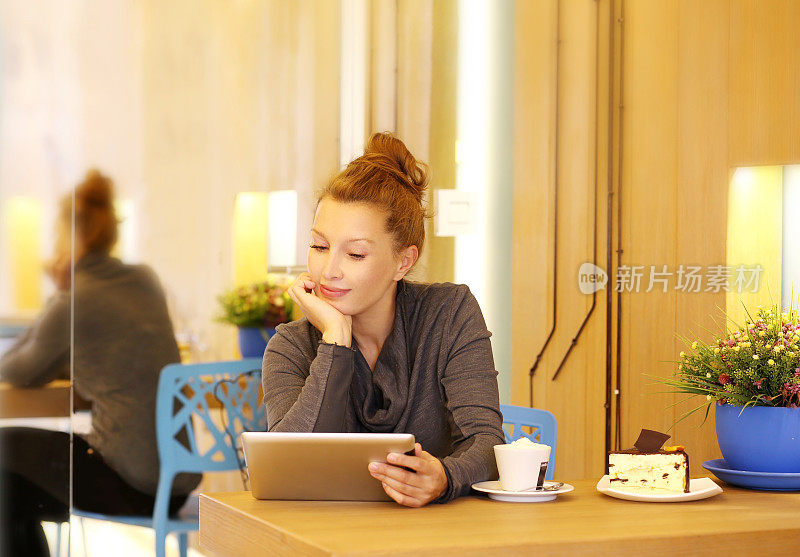 一个在咖啡馆里使用平板电脑的女人