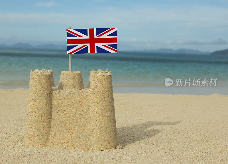 在大海前面挂着英国国旗的小沙堡