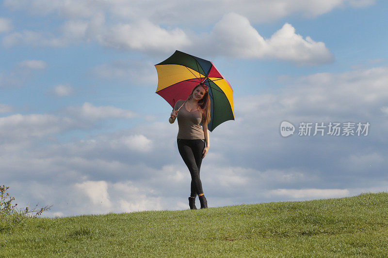 快乐的带着彩虹伞的身材优美的波兰户外女孩