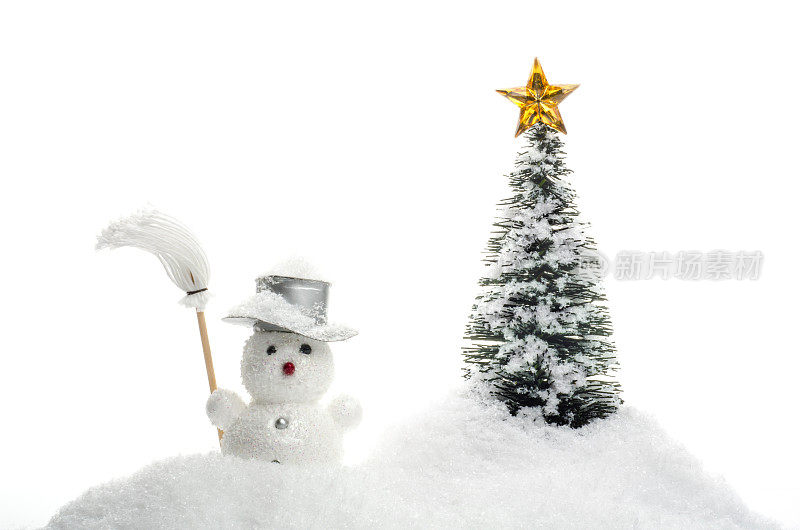 雪人与扫帚在雪与圣诞树