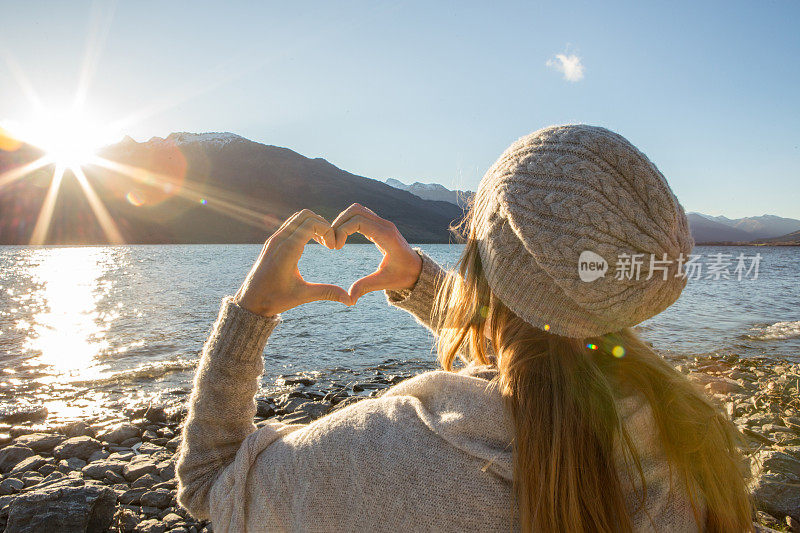 女人把美丽的风景画成心形