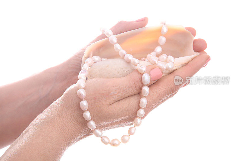 粉红色的贝壳，手里拿着粉红色的珍珠项链