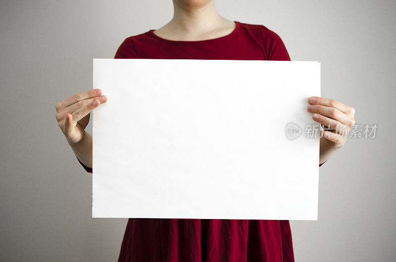 女人拿着一张空白的牌子，上面有复印空间