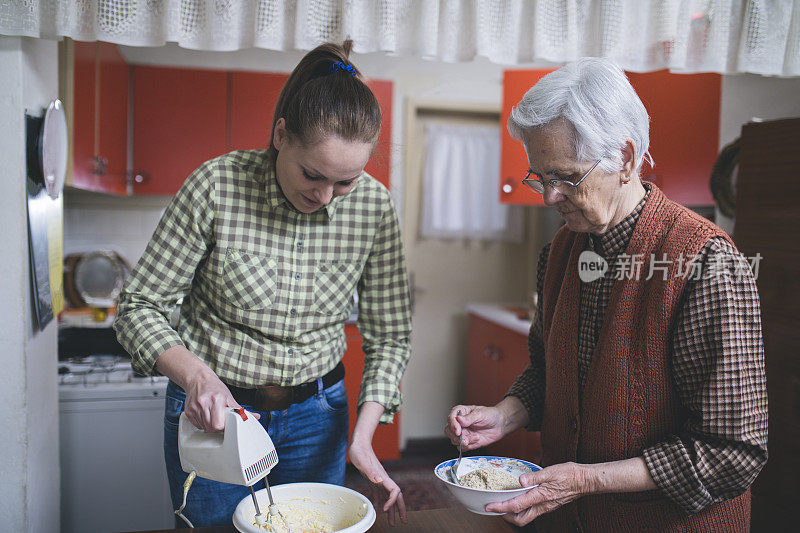 祖母和孙女烘烤饼干准备面团