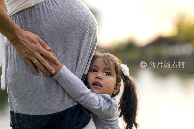 少数民族孕妇从她的小女儿拥抱