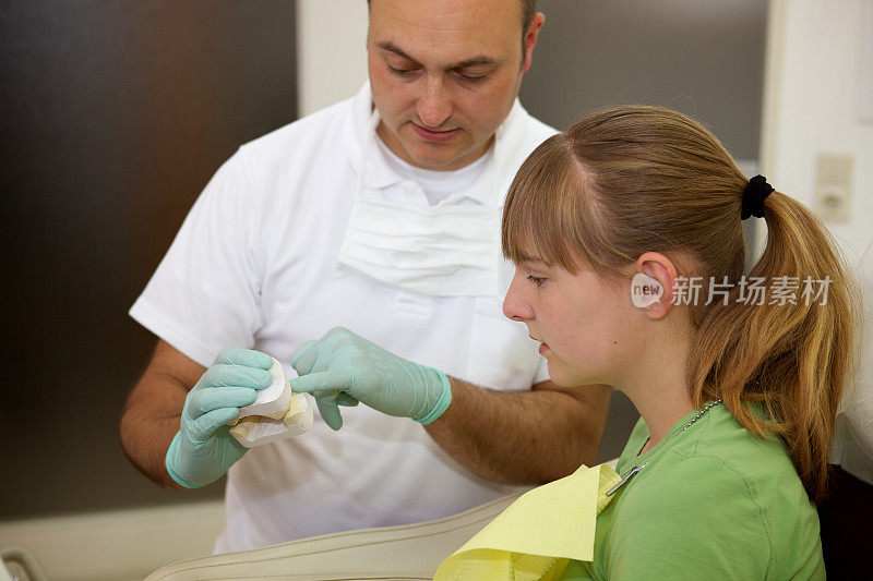 牙医向一个小女孩解释牙套