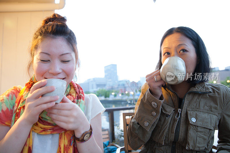 2个日本女人在享受饮料和蛋糕
