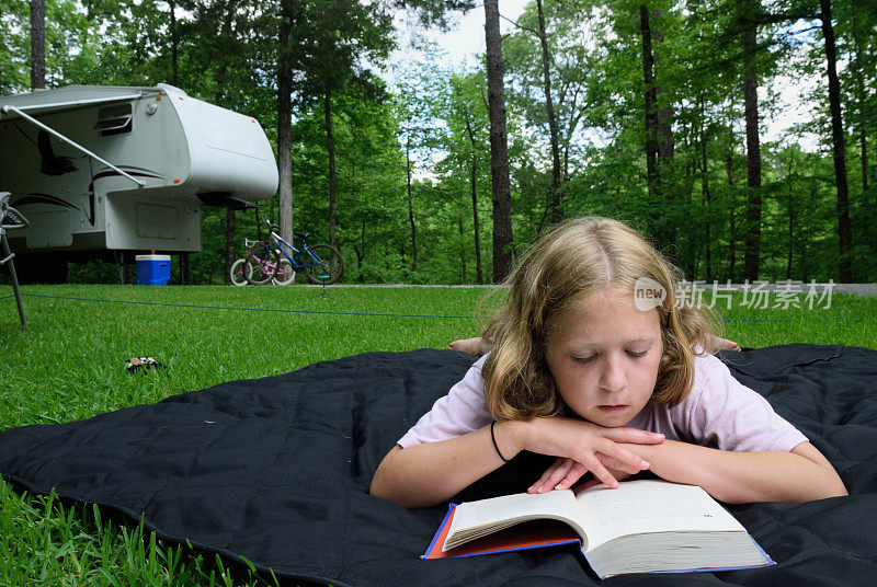 在房车露营地看书的女孩