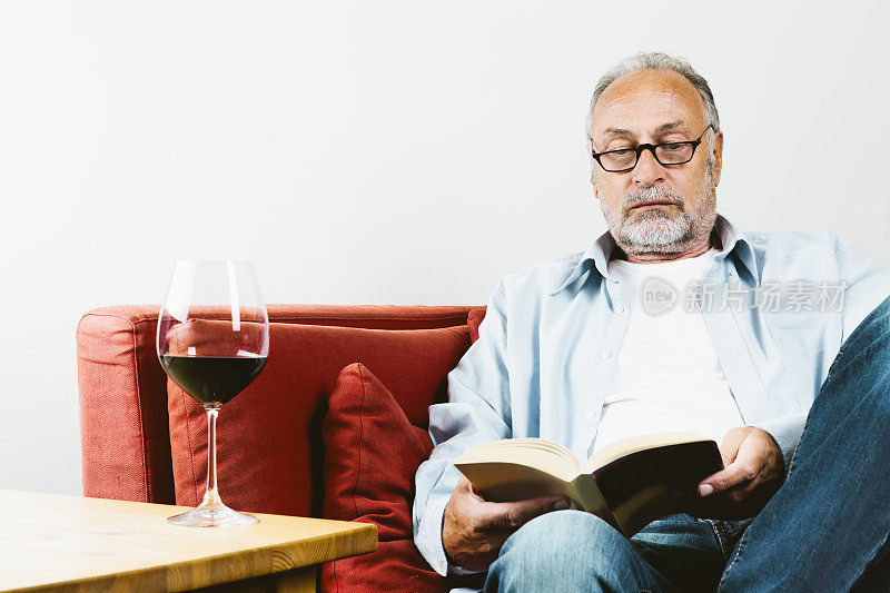 老人坐着，看书酒杯，红酒