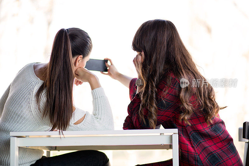 两个女孩在喝咖啡休息。