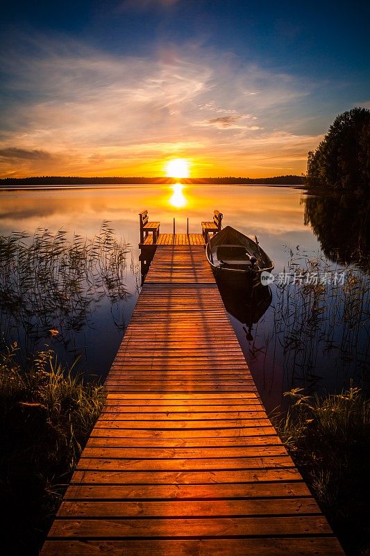 夕阳在芬兰湖边的钓鱼码头上