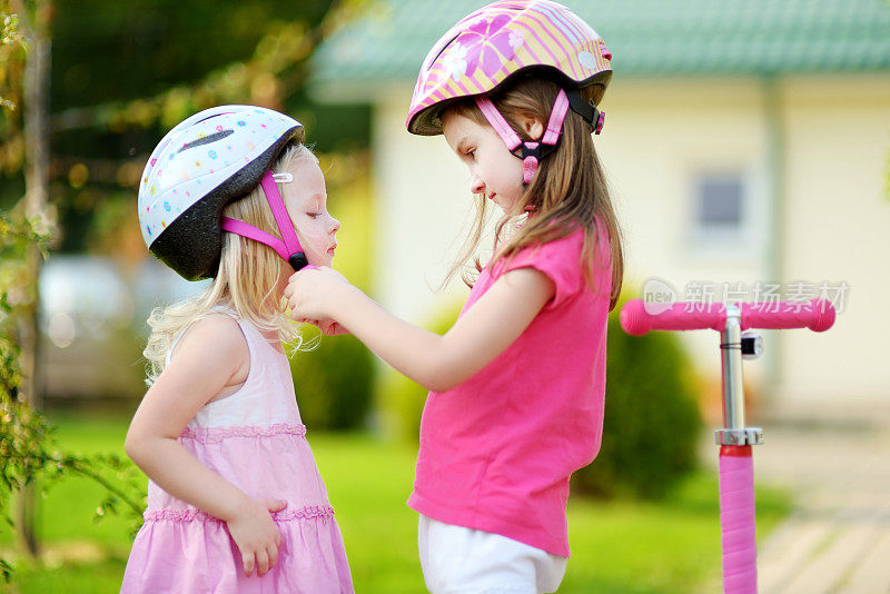 小女孩帮她姐姐戴上头盔