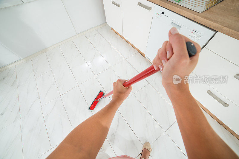 一个女人在用扫帚清理地板上的灰尘