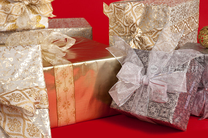 带蝴蝶结的圣诞包裹。包裹在红色背景上