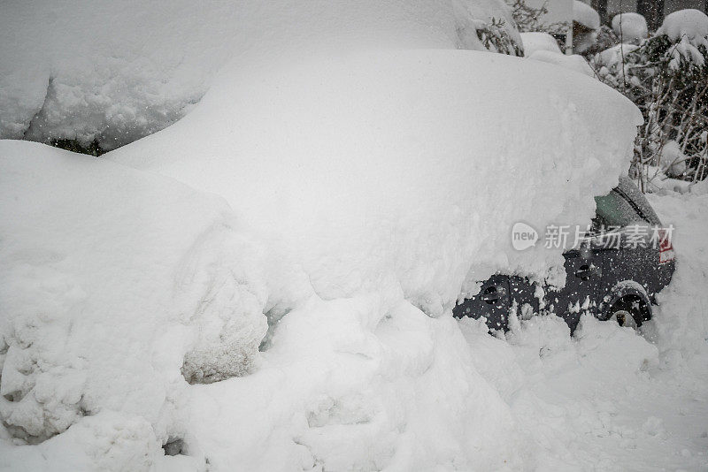 在德国巴伐利亚阿尔卑斯山的一条寒冷的道路上，一辆被雪覆盖的汽车。灾难预警