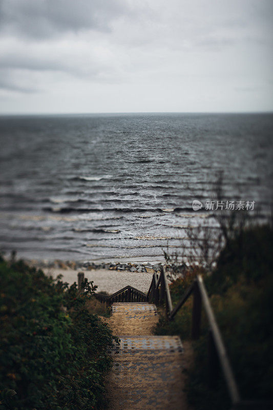 在灰蒙蒙寒冷的日子里，沿着陡峭的楼梯走到海边