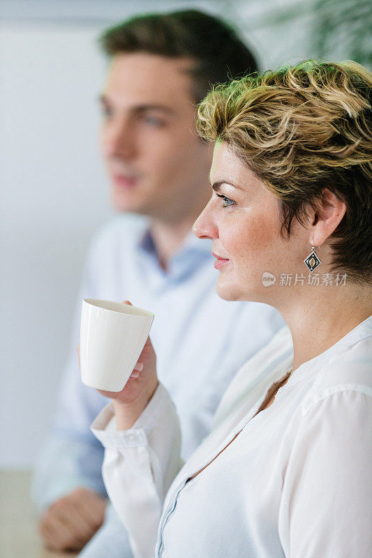 女商人拿着咖啡杯开会