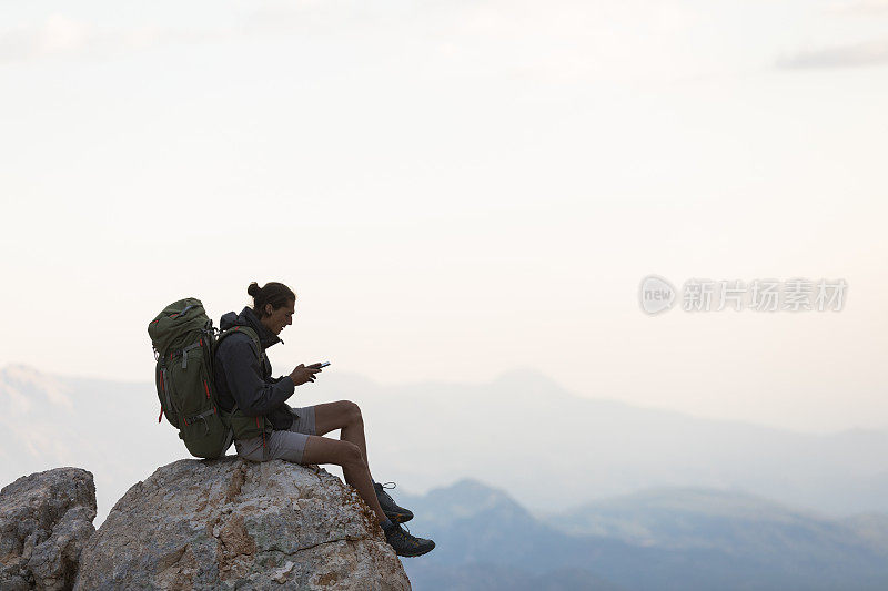 登山者在山顶使用智能手机