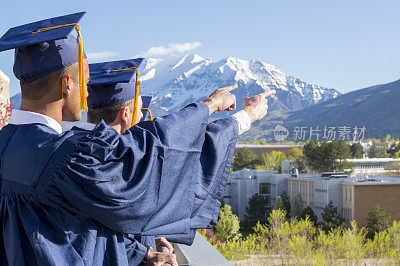 大学毕业生戴着学士帽和学士服望向群山和无限的可能性