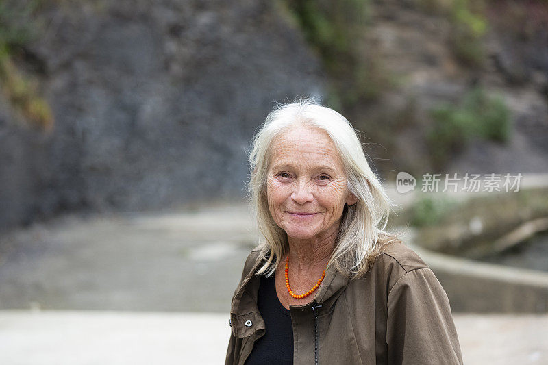 幸福成熟的女人在公园里的肖像，背景与复制空间