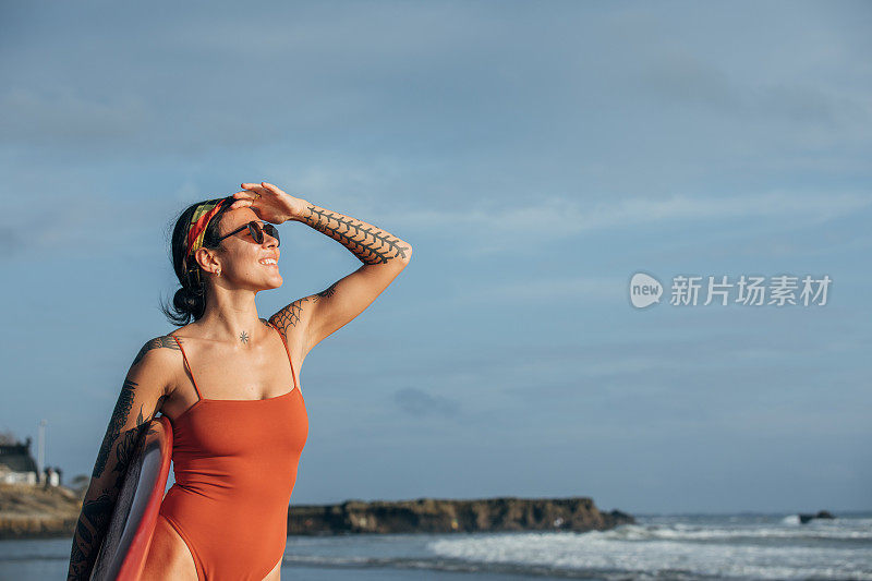 美丽的冲浪女士在看海浪