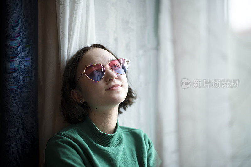 酷酷的现代少女戴着心形太阳镜在情人节