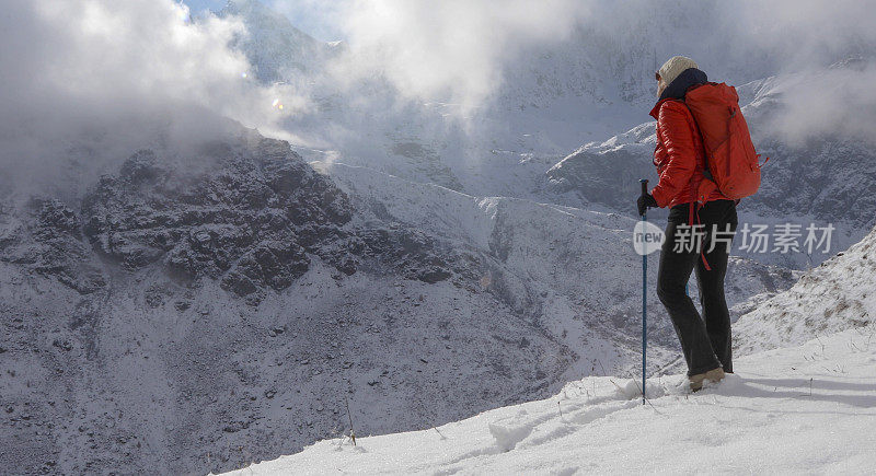 女登山家攀登雪坡，在山上