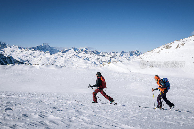 滑雪登山运动员攀登积雪的山脊线