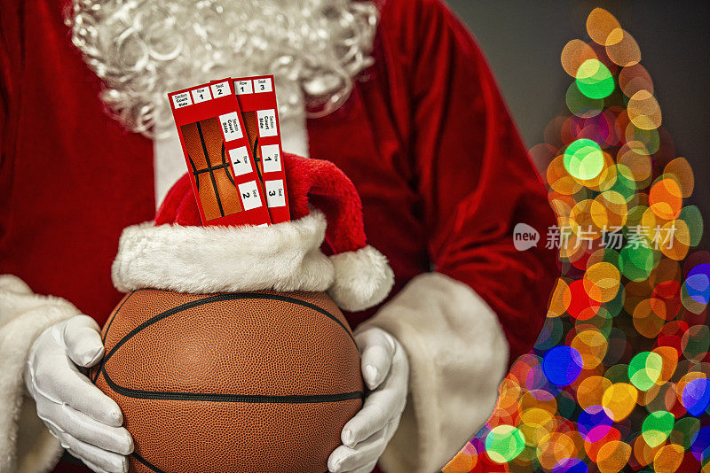 圣诞老人拿着两张篮球票，背景是一个蝴蝶结和来自圣诞树的散焦——季票