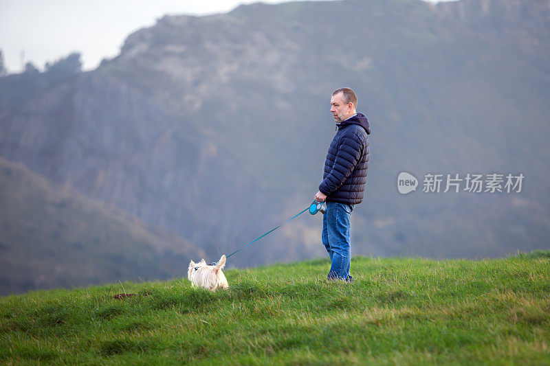 一个成熟的男人在山里遛狗