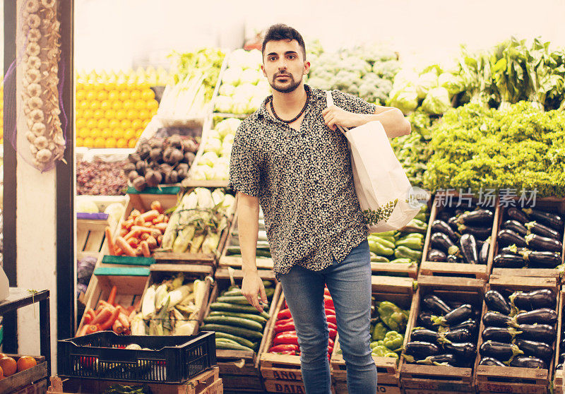 年轻人在农贸市场买水果和蔬菜