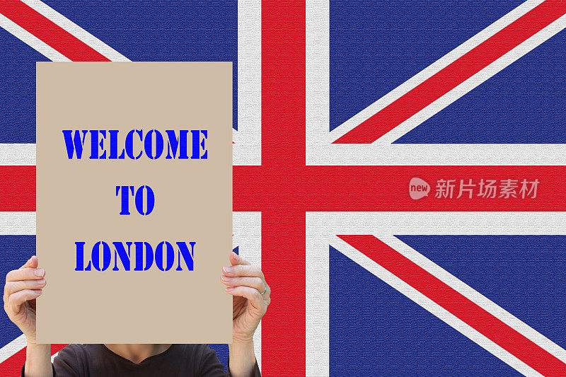 欢迎来到伦敦女子举着欢迎标志在一臂远的距离