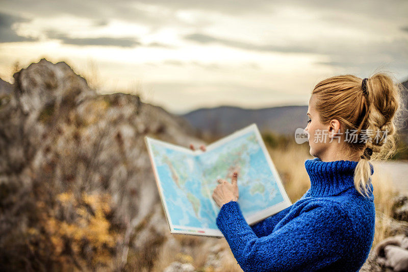 女旅行者在荒野地区查看地图寻找方向