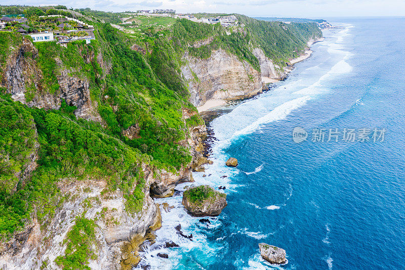 蓝色的海洋和被热带植物覆盖的悬崖。从上面看巴厘岛海岸。空中无人机拍摄。