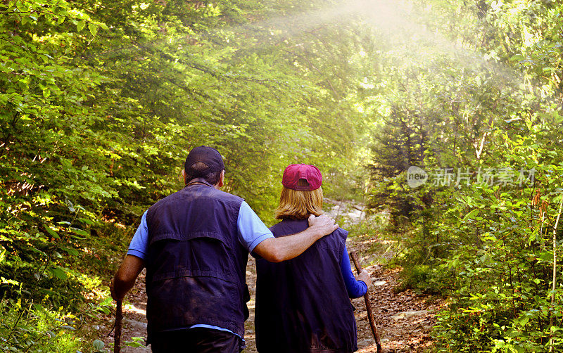 成熟的情侣一起在森林小径徒步旅行