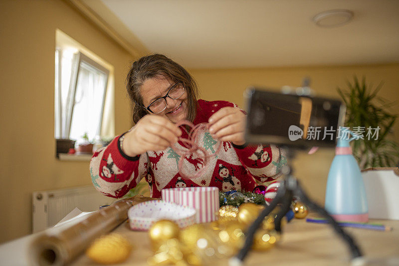 一位年长的女士在装饰圣诞节的时候正在打视频电话