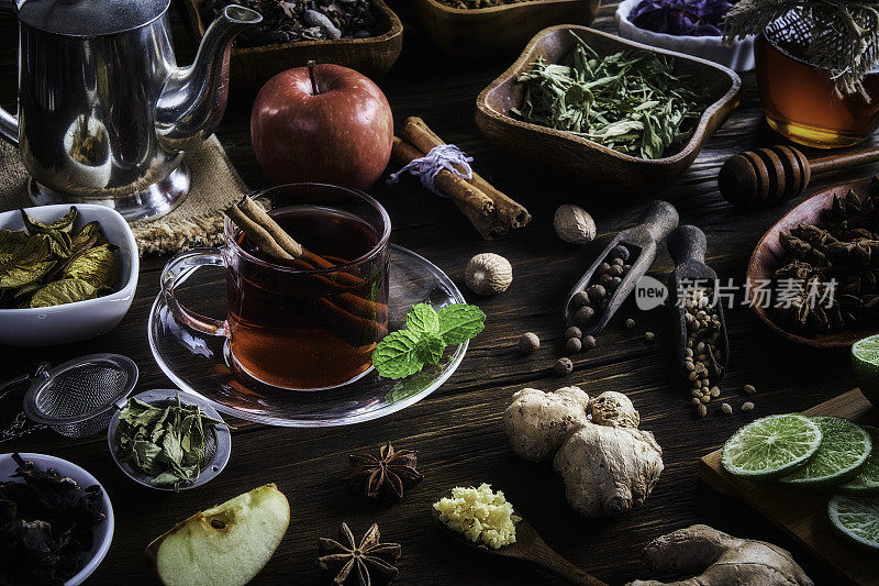 高角度的近景热茶芙蓉与肉桂棒在一个茶杯上的质朴的桌子