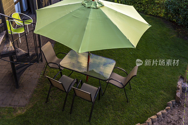 户外天井的桌椅和一把绿伞