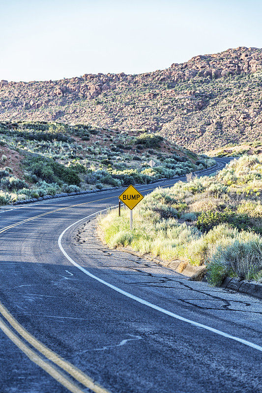 蜿蜒的犹他州高速公路上的黄色凹凸路面标志