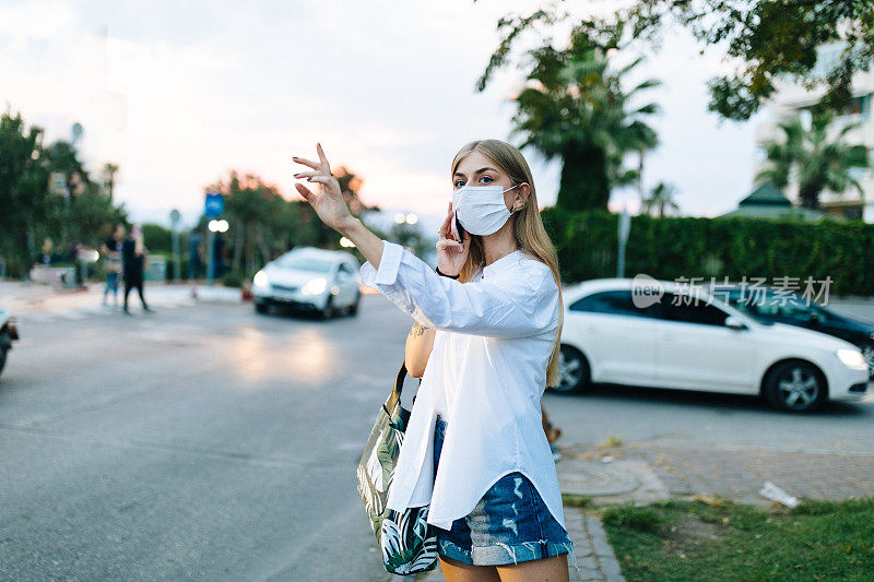 年轻的金发女人在等出租车