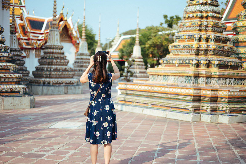 新常态旅游理念宽天使风景，亚洲女性游客穿着衣服享受拍照在佛寺和曼谷大广场，泰国新冠肺炎疫情期间