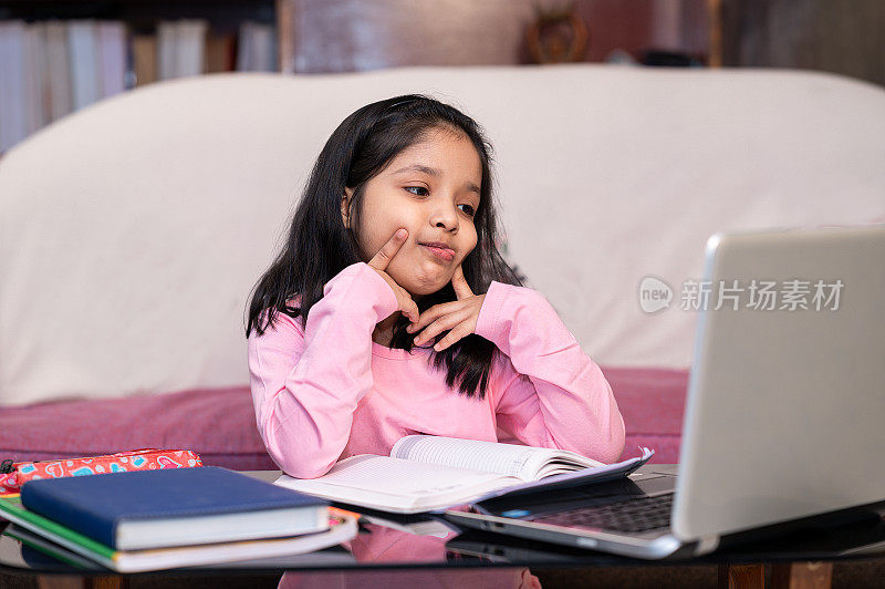 又累又烦的小女孩在家里用笔记本电脑学习