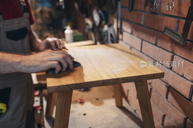 一个面目全非的工匠制作脚凳的手
