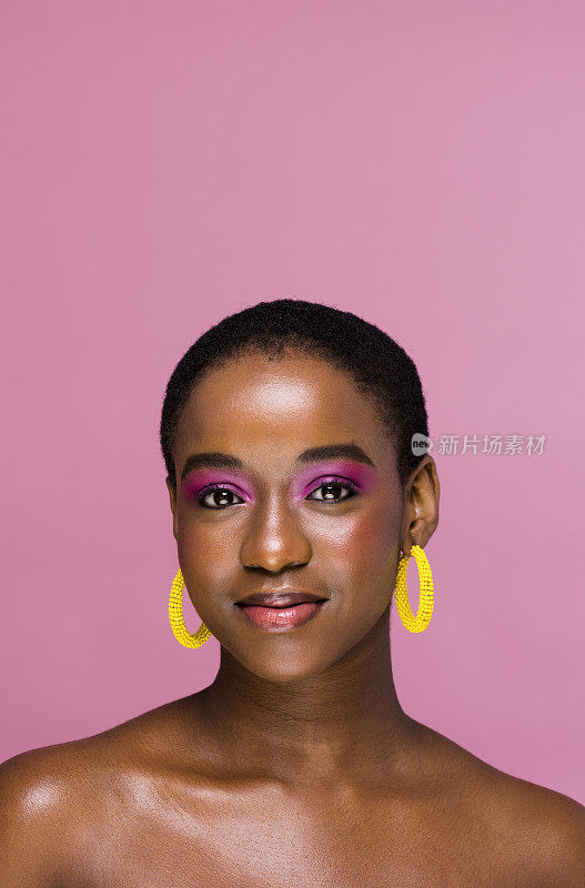 画室肖像自信的年轻非洲妇女与光泽的化妆和黄色环形耳环