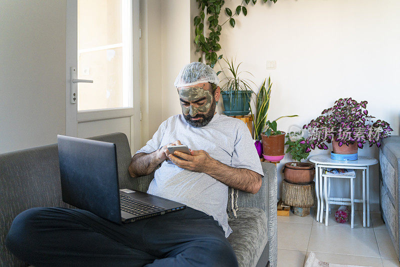 在家工作的人由于隔离而把粘土面罩涂在脸上