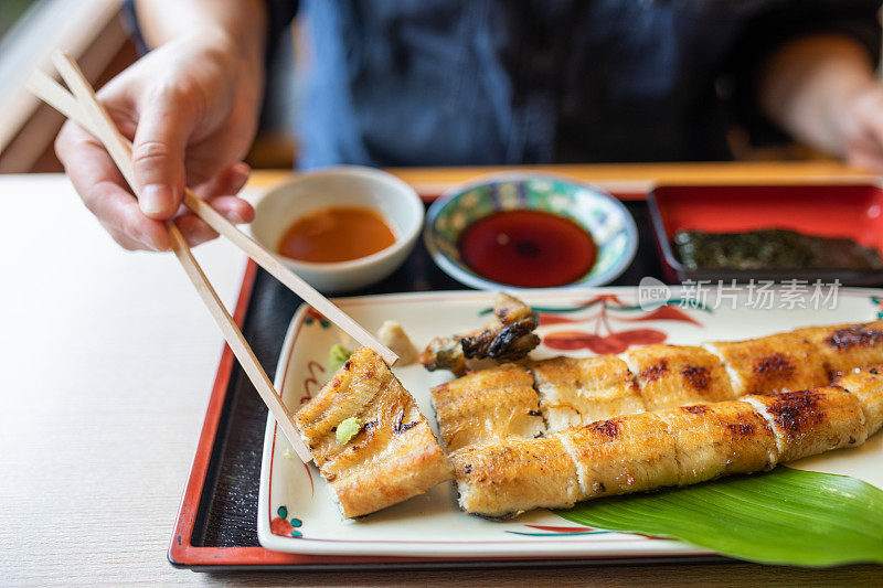 近距离的日本烤鳗鱼(Unagi)与芥末吃筷子