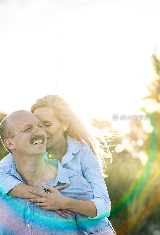 幸福可爱的夫妇与彩虹太阳耀斑在田园诗般的夏天肖像