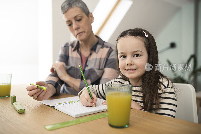 一个可爱的女孩和她妈妈做作业的肖像