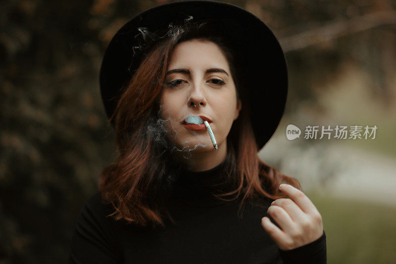 年轻的红发女人都穿着黑衣服，一边抽烟一边看着镜头