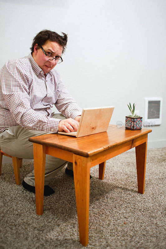 使用木制小桌子和木制笔记本电脑的书呆子办公室职员